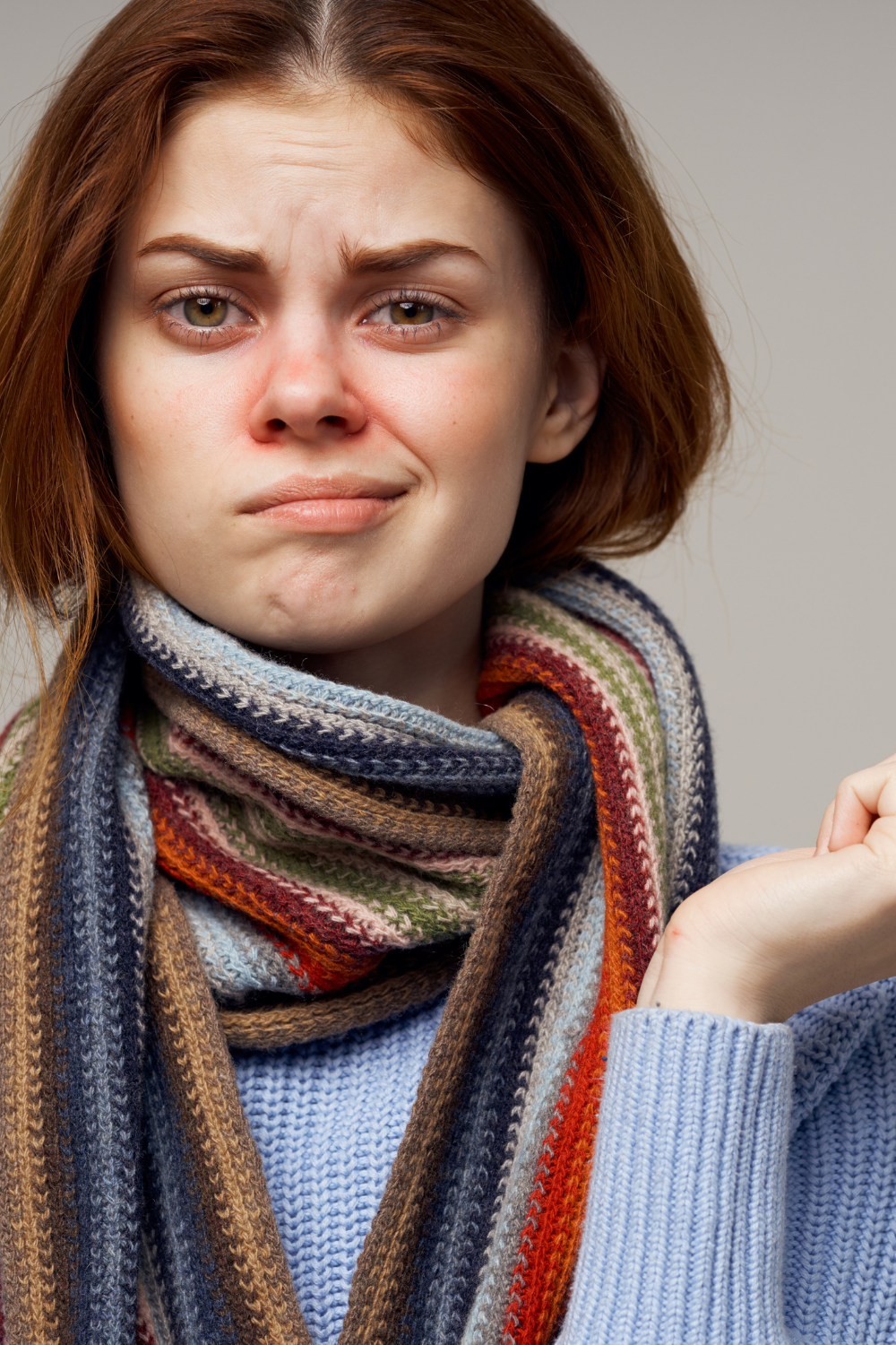 Woman with reddish hair and colourful scarf looking concerned - dark neck patches and PMOS | PCOS